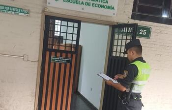 Un oficial de la policía toma notas del incidente en el aula de informática de la UNA.