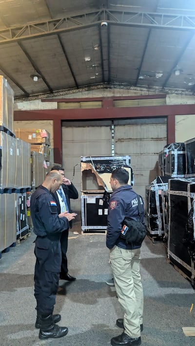 Policías y funcionarios de la terminal aérea conversan en el sitio donde se produjo el robado de mercaderías.
