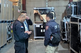Policías y funcionarios de la terminal aérea conversan en el sitio donde se produjo el robado de mercaderías.
