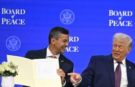 El presidente de Paraguay, Santiago Peña (izq.), sostiene un acta fundacional firmada mientras el presidente estadounidense, Donald Trump, reacciona en la reunión de la "Junta de la Paz" durante la reunión anual del Foro Económico Mundial (FEM) en Davos el 22 de enero de 2026.