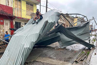 Un residente se sienta sobre parte del techo de su casa, dañada por el huracán Melissa, en Santiago de Cuba, el 29 de octubre de 2025.