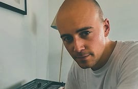 Daniel O'Loughlin , vestido de forma casual, tocando un teclado con expresión tranquila.