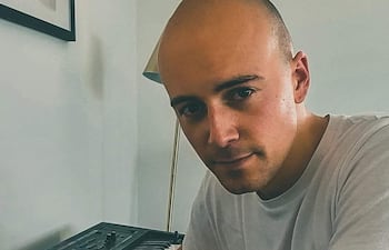 Daniel O'Loughlin , vestido de forma casual, tocando un teclado con expresión tranquila.