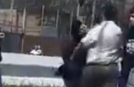 Captura de pantalla del video en el que se muestra a un hombre agrediendo a estudiantes adolescentes en la vía pública.