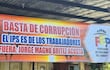 Gran cartel en colores naranjas y rojos que dice: 'BASTA DE CORRUPCIÓN EL IPS ES DE LOS TRABAJADORES FUERA: JORGE MAGNO BRITEZ ACOSTA'.