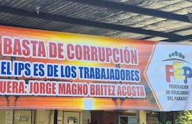 Gran cartel en colores naranjas y rojos que dice: 'BASTA DE CORRUPCIÓN EL IPS ES DE LOS TRABAJADORES FUERA: JORGE MAGNO BRITEZ ACOSTA'.