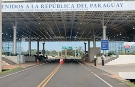 Funcionarios de seguridad en uniforme observan el tráfico en un moderno punto de control en Paraguay.