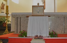 Altar decorado con flores y vela amarilla, simbolizando el ambiente religioso de la ceremonia. La reliquia -ex cineribus corporis- ( de los restos corporales) de San Francisco de Asís.