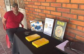 El suboficial inspector Freddy Alcides Martínez Ferrari, con las evidencias, los dos paquetes de cocaína prensada, que fueron encontradas en su poder. El procedimiento contra el narcotráfico se realizó hoy en Mariano Roque Alonso.