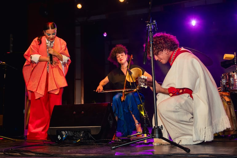 Celebrantes sonrientes en evento del Centro Cultural, con pastel '50', en ambiente festivo y decorado.