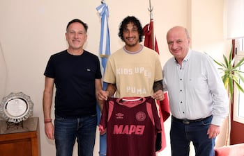 El zaguero paraguayo José María Canale junto al presidente Nicolás Russo y el vicepresidente Alejandro Marón de Lanús, tras la extensión de contrato del defensor.