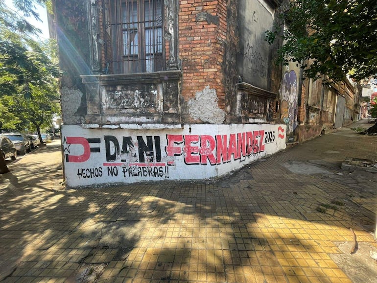 Mural grafiteado con la frase 'DANI FERNANDEZ 2026 HECHOS NO PALABRAS!!' en una pared de ladrillos expuestos.