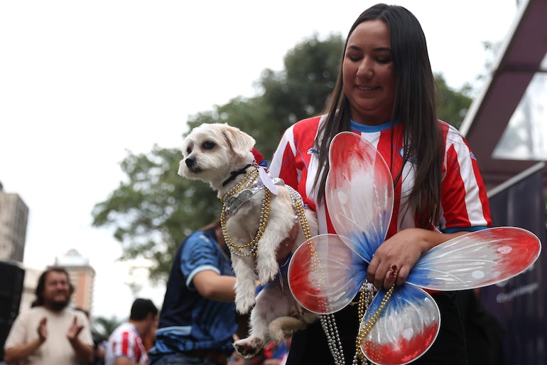 Una mujer sostiene un perro durante el desfile de la celebración delJagua Patriotaeste jueves, en Asunción.