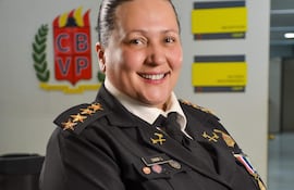 Lorena Canan en uniforme negro con condecoraciones sonríe, en un ambiente institucional decorado con el logo CBVP.
