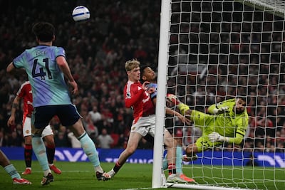 Arsenal's Spanish goalkeeper #22 David Raya (R) pushes the ball away on the goalline during the English Premier League football match between Manchester United and Arsenal at Old Trafford in Manchester, north west England, on March 9, 2025. (Photo by Paul ELLIS / AFP) / RESTRICTED TO EDITORIAL USE. No use with unauthorized audio, video, data, fixture lists, club/league logos or 'live' services. Online in-match use limited to 120 images. An additional 40 images may be used in extra time. No video emulation. Social media in-match use limited to 120 images. An additional 40 images may be used in extra time. No use in betting publications, games or single club/league/player publications. /
