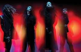 Korn en el escenario, con miembros vestidos de forma casual, luces brillantes y un ambiente energético previo al show.