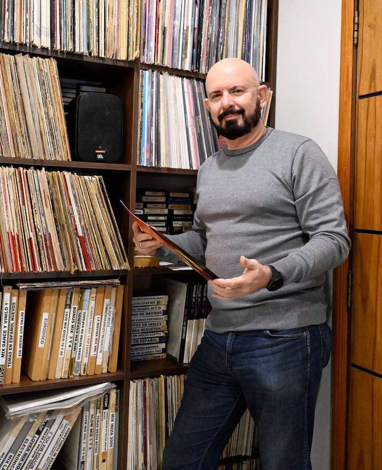 Jorge Puig manipula un equipo de audio analógico en su colección en Lambaré.