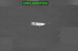 Bote solitario en el mar, capturado en visión nocturna, sin personas visibles en la escena, en un ambiente sereno.