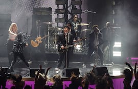 La cantante neozelandesa-surcoreana Rose (izq.) y el cantautor estadounidense Bruno Mars (centro) actúan en el escenario durante la 68.ª ceremonia anual de los Premios Grammy.