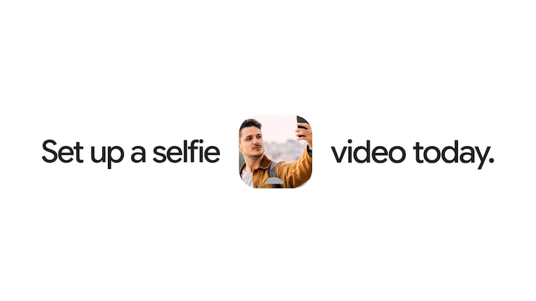 Hombre sonriente, tranquilo y con vestimenta casual, sostiene un teléfono móvil mientras se prepara para grabar un videoselfie.