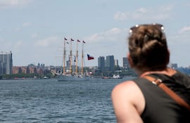 Una persona observa navegar un velero con la bandera de Chile este sábado, en Nueva York (Estados Unidos).