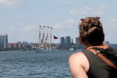Una persona observa navegar un velero con la bandera de Chile este sábado, en Nueva York (Estados Unidos).