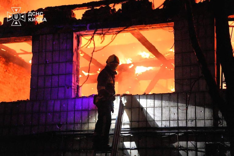 Un bombero trabaja en el sitio de un incendio provocado por un bombardeo ruso hoy en Kiev.