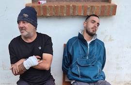 Luis Carlos Ferreira Martínez (vendado) y su hijastro Lucas Ramón Ferreira García (campera azul), detenidos en Encarnación por el doble homicidio en Cambyretá.