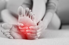 Persona con espasmos musculares dolorosos en los pies, imagen ilustrativa.