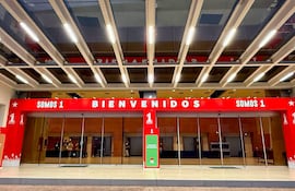 Entrada del edificio de Conmebol decorada con letreros que dicen 'BIENVENIDOS' y 'SOMOS 1' en un ambiente moderno.