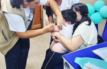 Una enfermera aplica una vacuna contra el sarampión a un niño.