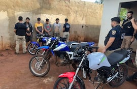 Policías de Homicidios con los cuatro aprehendidos y las motocicletas incautadas.