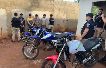 Policías de Homicidios con los cuatro aprehendidos y las motocicletas incautadas.