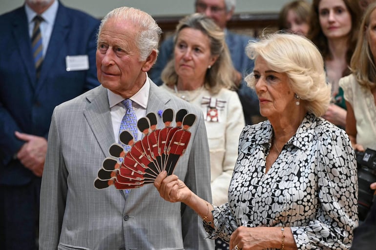 La reina Camilla de Gran Bretaña y el rey Carlos III de Gran Bretaña escuchan una representación de la Ópera de Dorset, durante una visita al Salón Principal del Ayuntamiento y la Bolsa de Maíz de Blandford Forum en Blandford Forum, Dorset, suroeste de Inglaterra, ayer 16 de julio de 2026. (JUSTIN TALLIS / POOL / AFP)