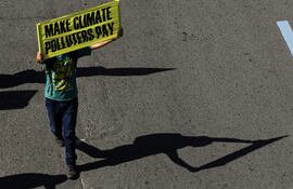 Un manifestante con un cartel que reza "Que los contaminadores paguen" en Quezon, Filipinas, el pasado sábado.