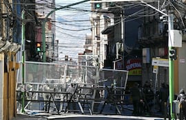 La policía bloquea una calle que conduce a la plaza Murillo en La Paz, el 19 de mayo de 2026, un día después de una protesta que exigía la renuncia del presidente boliviano Rodrigo Paz. Las protestas bolivianas que pedían la renuncia del presidente de centroderecha Rodrigo Paz se intensificaron el 18 de mayo de 2026, cuando los manifestantes rodearon edificios gubernamentales y un líder de las protestas enfrentó cargos de terrorismo por los disturbios. La policía antidisturbios se enfrentó a los manifestantes durante horas, los gases lacrimógenos cubrieron las calles de La Paz, los comercios cerraron y los suministros escasearon debido a los bloqueos de las protestas que obstruían las rutas de acceso a la capital.