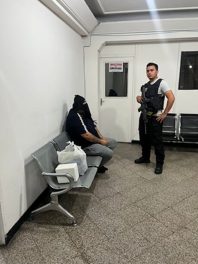 Maykon De Souza, cabeza del Primer Grupo Catarinense, esposado y encapuchado, esperando ser expulsado del país.