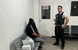 Maykon De Souza, cabeza del Primer Grupo Catarinense, esposado y encapuchado, esperando ser expulsado del país.