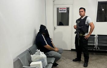 Maykon De Souza, cabeza del Primer Grupo Catarinense, esposado y encapuchado, esperando ser expulsado del país.