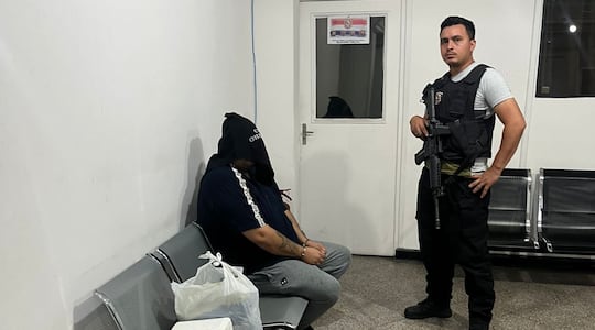 Maykon De Souza, cabeza del Primer Grupo Catarinense, esposado y encapuchado, esperando ser expulsado del país.