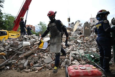 Colombian firefighters remove debris at the Torres del Limonar residential complex, located in the Capri neighborhood in southern Cali, Colombia, on August 16, 2026, after a 7.4- magnitude earthquake. At least 287 people have died, thousands have been injured and about 379 remain unaccounted for, as the chances of finding earthquake survivors have dropped sharply since the critical 72-hour window passed, though volunteers and rescue crews continue digging through the rubble for any signs of life. (Photo by Raul ARBOLEDA / AFP)