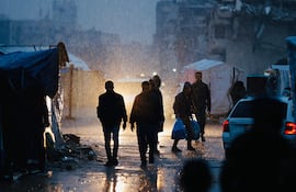 Palestinos desplazados caminan bajo la lluvia en la Ciudad de Gaza, el pasado lunes.