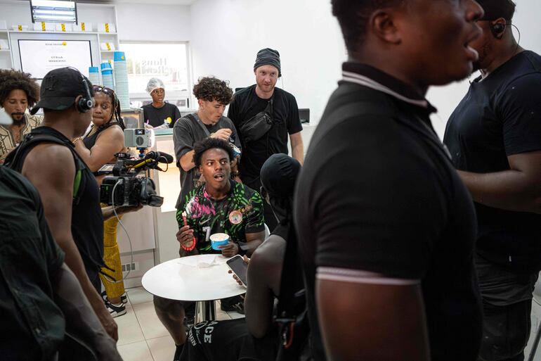 El youtuber y streamer estadounidense Darren Jason Watkins Jr., más conocido como IShowSpeed (centro), prueba un helado rodeado de guardaespaldas y seguidores durante un evento en el centro comercial Admiralty Mall, en Lagos, el 21 de enero de 2026.