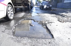 Enorme y profundo bache sobre Artigas casi General Santos. La presencia de agua servida imposibilita la visualización a los conductores.
