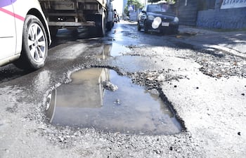 Enorme y profundo bache sobre Artigas casi General Santos. La presencia de agua servida imposibilita la visualización a los conductores.