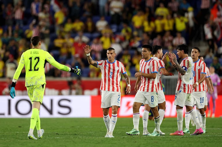 Orlando Gill de Paraguay celebra la victoria con sus compañeros Alan Benítez y Diego Gómez después del partido amistoso internacional entre Colombia y Paraguay en el Sports Illustrated Stadium, en Harrison, Nueva Jersey.