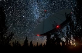 Radiotelescopio, una gran antena satelital contra el cielo nocturno, rastrea a las estrellas. Imagen ilustrativa de la búsqueda de vida extraterrestre, o interceptación del espacio.