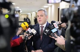 Camilo Benítez Aldana en el centro, hablando a varios periodistas, con micrófonos de medios de comunicación locales alrededor.