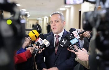 Camilo Benítez Aldana en el centro, hablando a varios periodistas, con micrófonos de medios de comunicación locales alrededor.