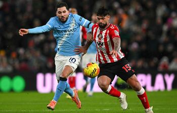 El centrocampista francés del Manchester City, Rayan Cherki (izq.), disputa el balón con el defensor paraguayo del Sunderland, Omar Alderete (der.), durante el partido de fútbol de la Premier League inglesa entre el Sunderland y el Manchester City en el Stadium of Light en Sunderland.